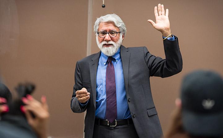 Photo of BW Professor Raising Hand in Front of Class